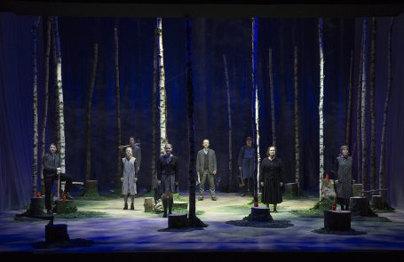 Tannöd - Theater Hof Theateraufführung in einem Wald mit sieben Darstellern zwischen Bäumen.