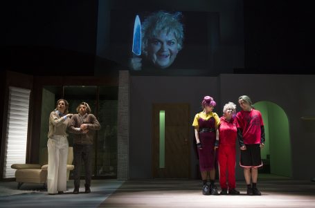 Eine Mords-Freundin Szenen aus einem Theaterstück mit Schauspielern und einer Projektion eines bedrohlichen Gesichts.