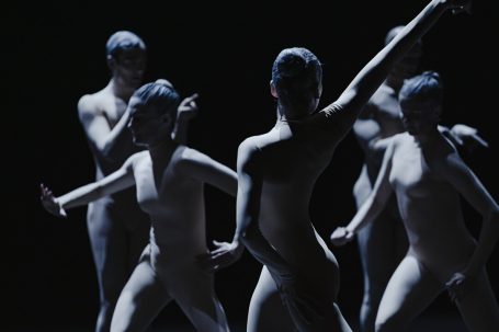 Corps de Walk - Staatstheater Wiesbaden Fünf silhouettenhafte Tänzer in ausdrucksvoller Pose vor schwarzem Hintergrund.